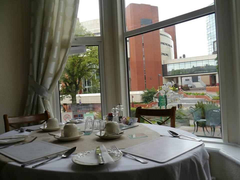 una mesa con un mantel blanco y una ventana en Conference View Guest House, en Harrogate