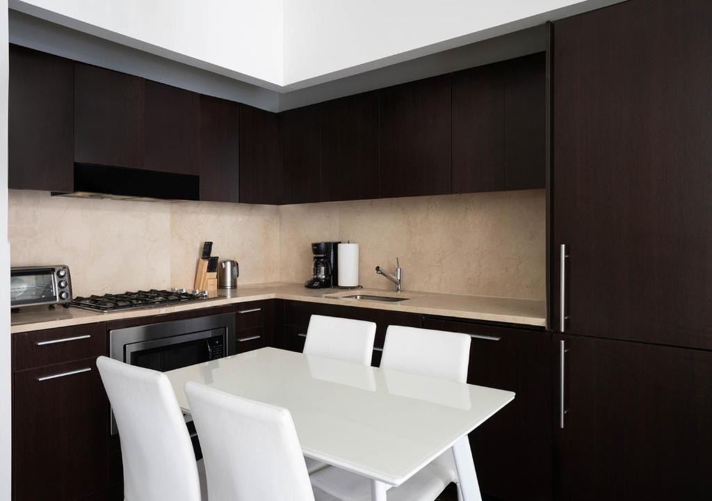 cocina con mesa blanca y sillas blancas en 2BD 1BA Apartment At Wall Street, en Nueva York