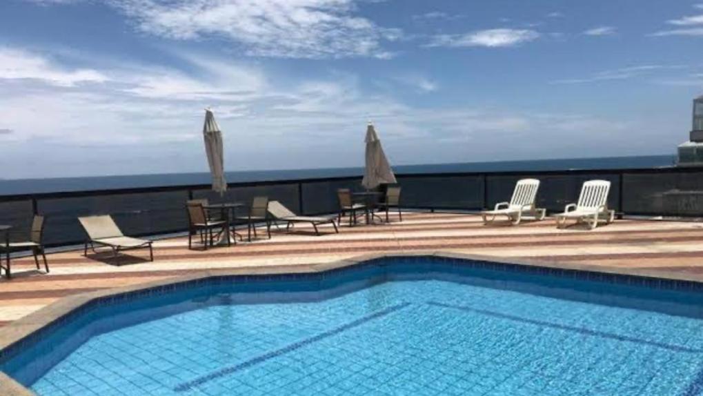 a swimming pool on the roof of a building at Loft Pituba Sol in Salvador
