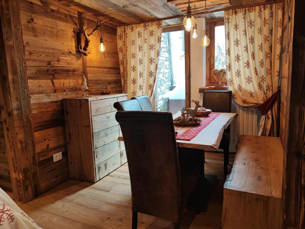 a dining room with a table in a log cabin at La Maison Derby in La Salle