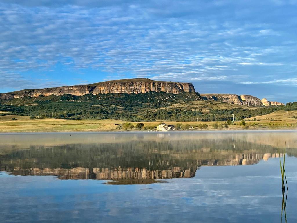 een berg met zijn reflectie in een lichaam van water bij Buffalo Hills Private Game Reserve in Harrismith