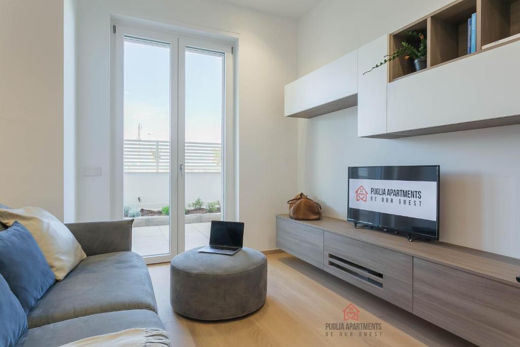 a living room with a couch and a tv at Casa 7 Mari - BARI Fiera del Levante - Puglia Apartments in Bari