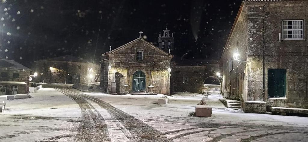 a stone building in the snow at night at Casa Aldeia da Lapa in Sernancelhe