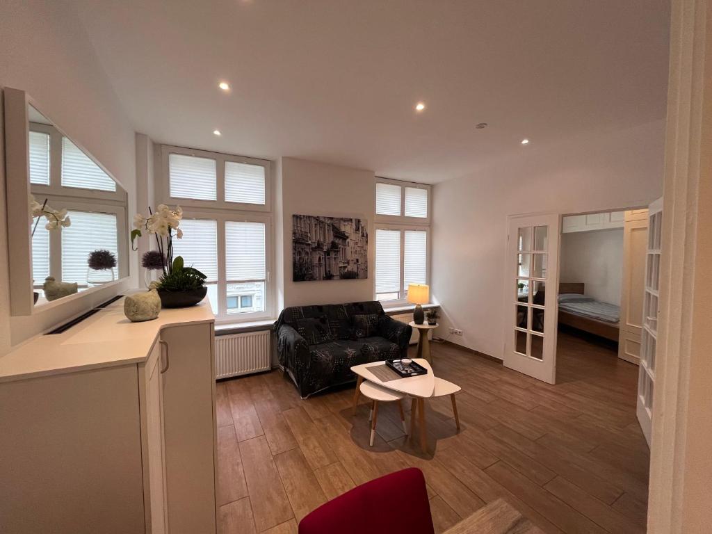 uma sala de estar com um sofá e uma mesa em Altbau trifft Moderne, neuwertige Komfortwohnung für bis 2 Personen em Wuppertal