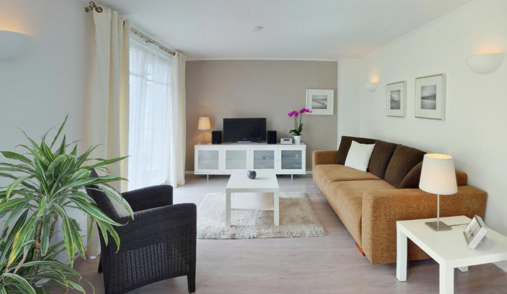 a living room with a couch and a table at Meer Residenz Warnemuende in Warnemünde