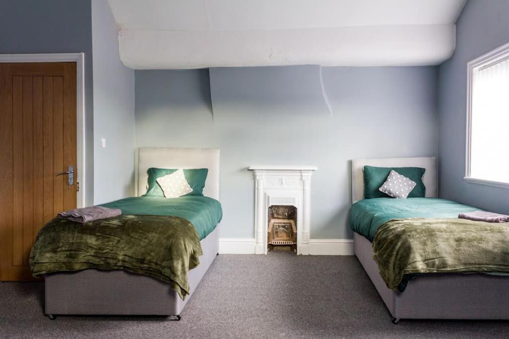2 Betten in einem Zimmer mit blauen Wänden in der Unterkunft Modern 5 Bed Near LFC Stadium in Liverpool