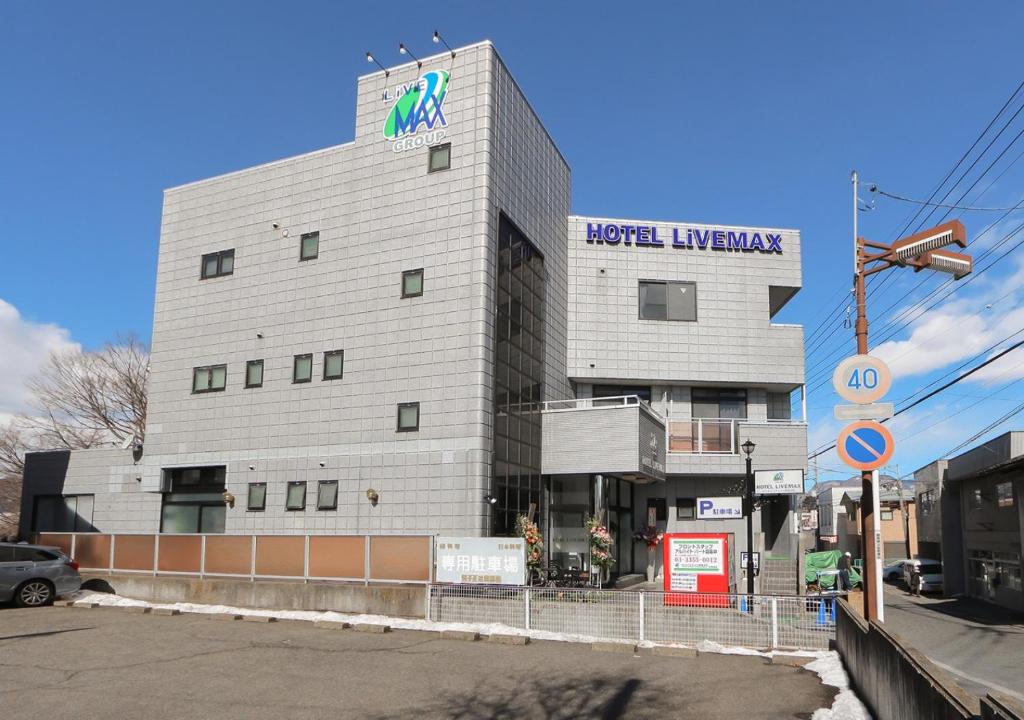 un edificio con un cartel en el costado en HOTEL LiVEMAX BUDGET Gunma Numata, en Numata