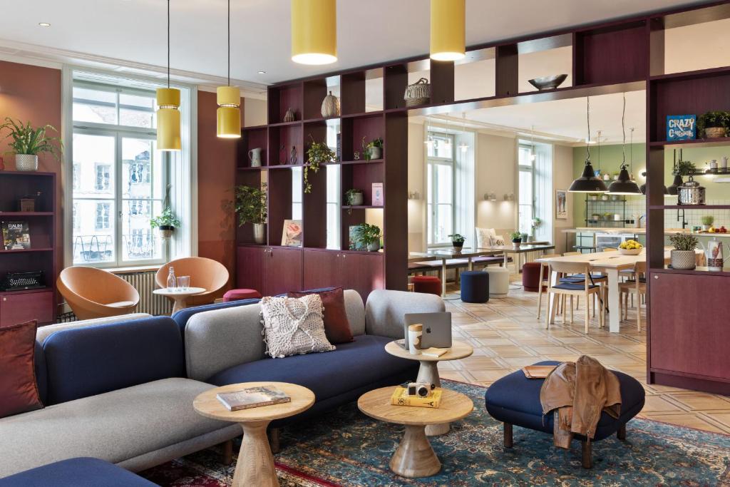 ein Wohnzimmer mit einem blauen Sofa und einer Küche in der Unterkunft Stay KooooK Bern City - Online Check In in Bern