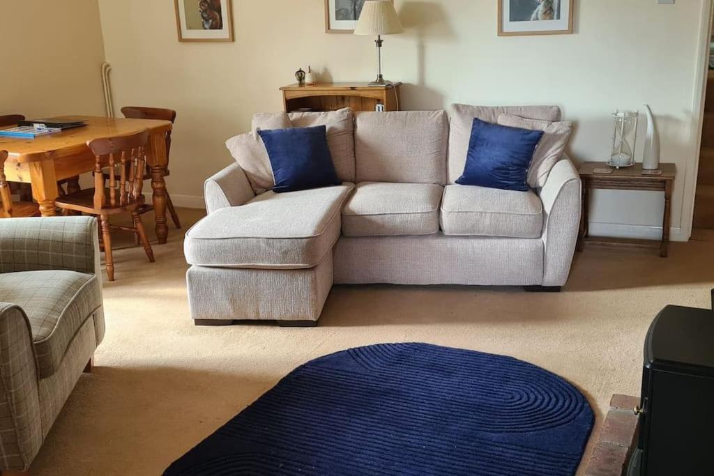 a living room with a couch and blue pillows at Two Bed First Floor Apartment in Village location in Grantham