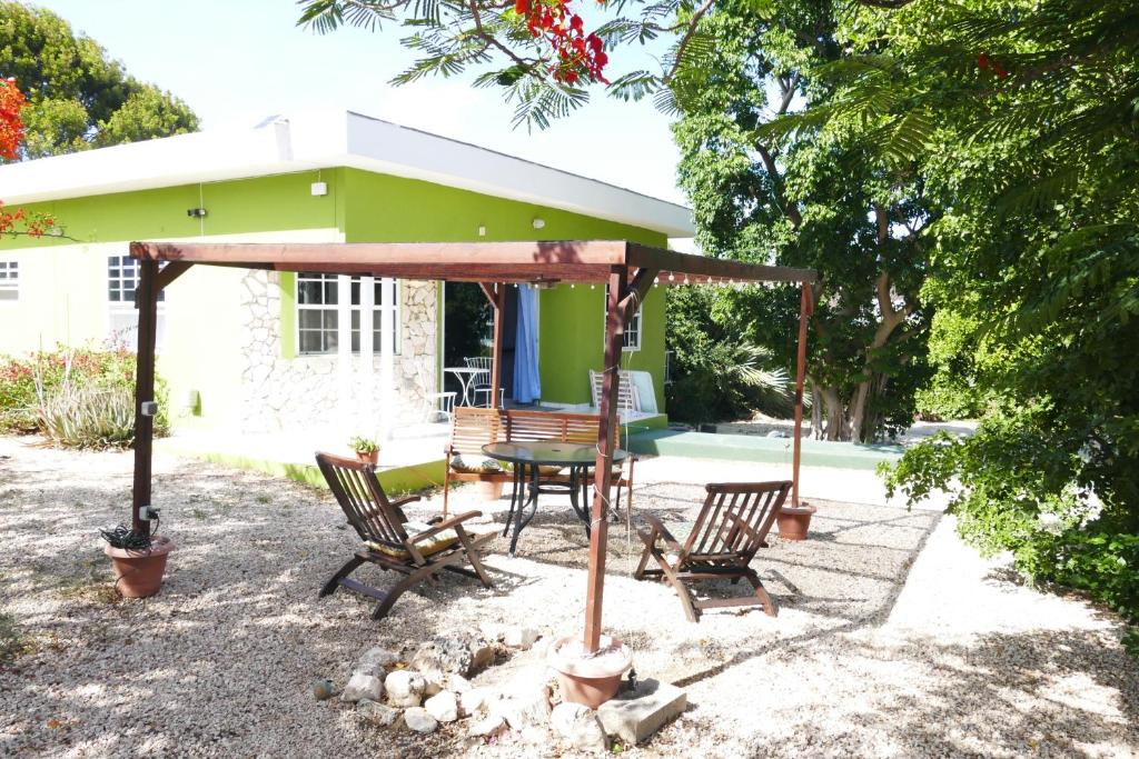 eine Terrasse mit einem Tisch und Stühlen vor einem Haus in der Unterkunft Resident Emiterio in Blue Bay