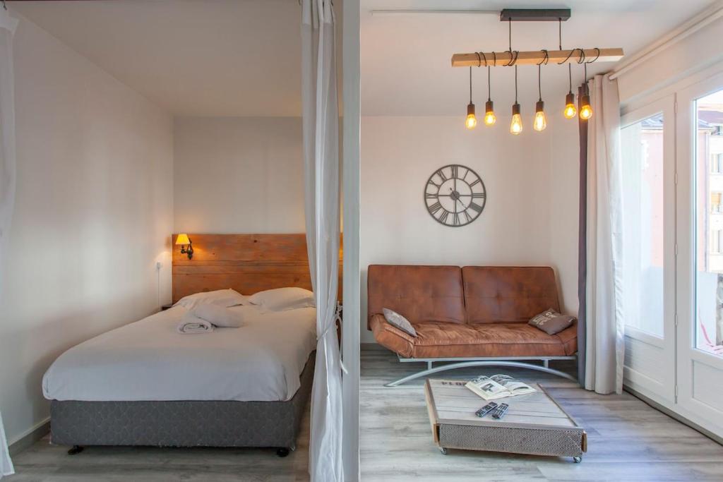 um quarto com uma cama, um sofá e uma mesa em Montagnes russes em Grenoble