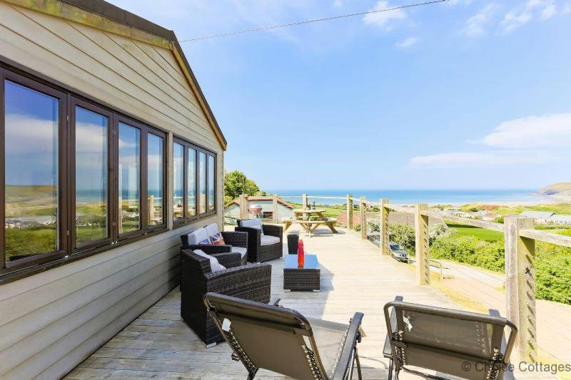 a porch with two chairs and furniture on the beach at CROYDE ILUKA 3 Bedrooms in Croyde