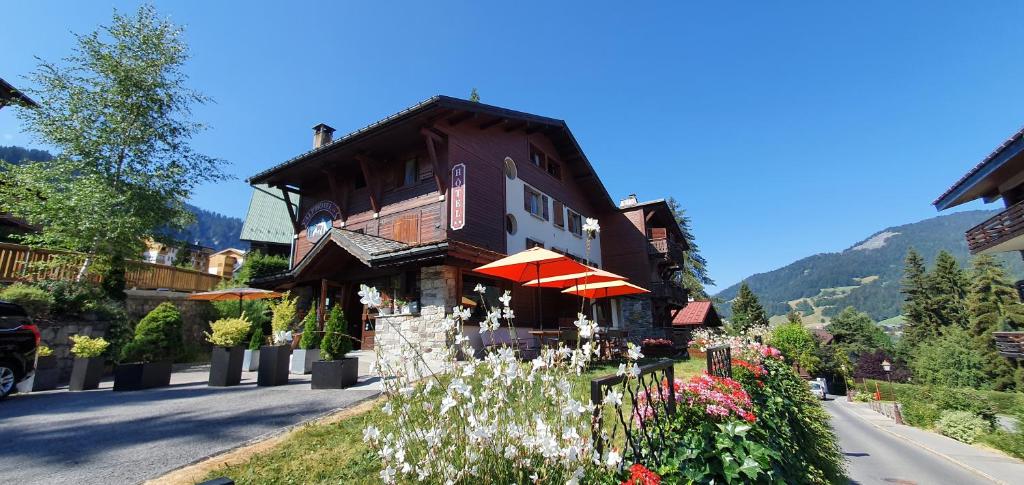 a building with flowers on the side of a street at Alp-Hôtel in Megève