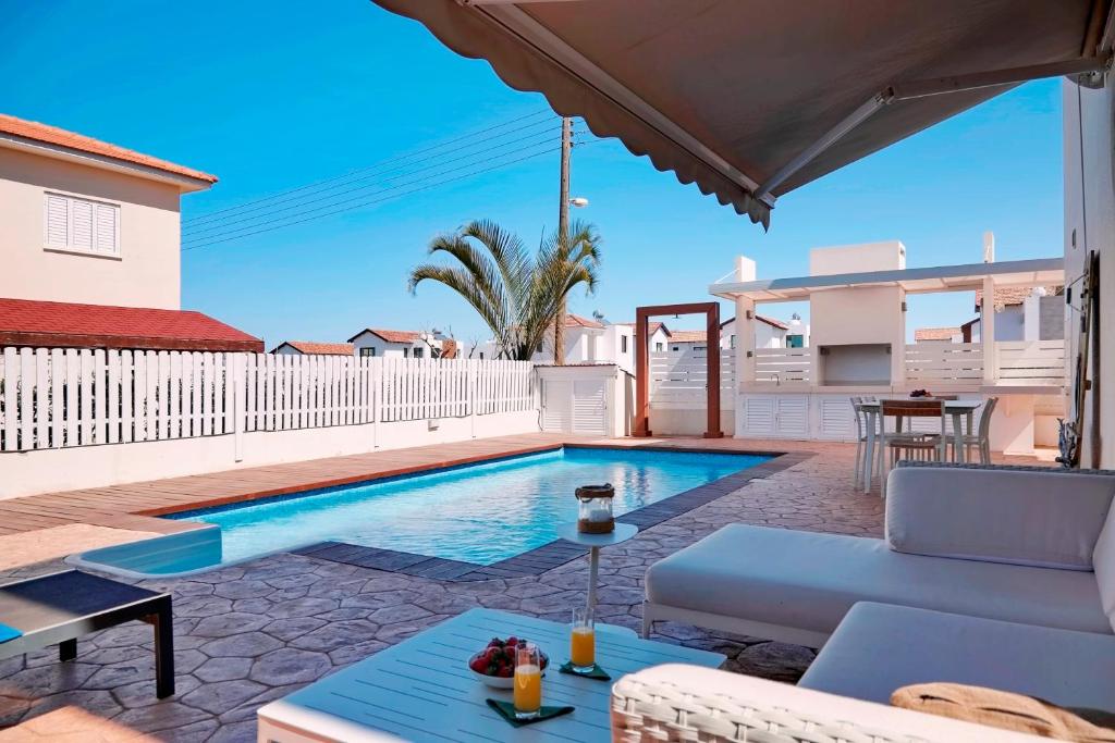 a villa with a swimming pool and a patio at Velomar Villa in Paralimni