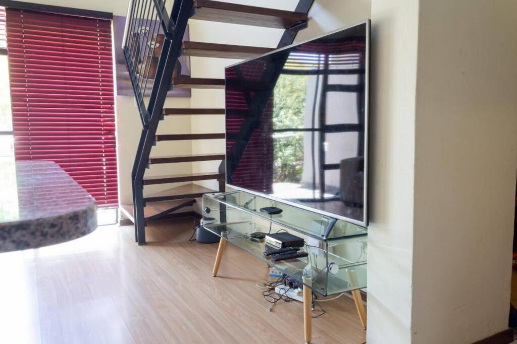 Sala de estar con escalera y espejo en Stunning 2 Bedroom Inverter , WiFi Inside Golf Estate en Northriding