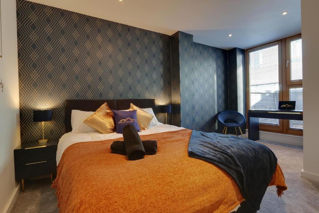 a bedroom with a large bed with a orange blanket at Home Away From Home - Contractors & Leisure in Sheffield
