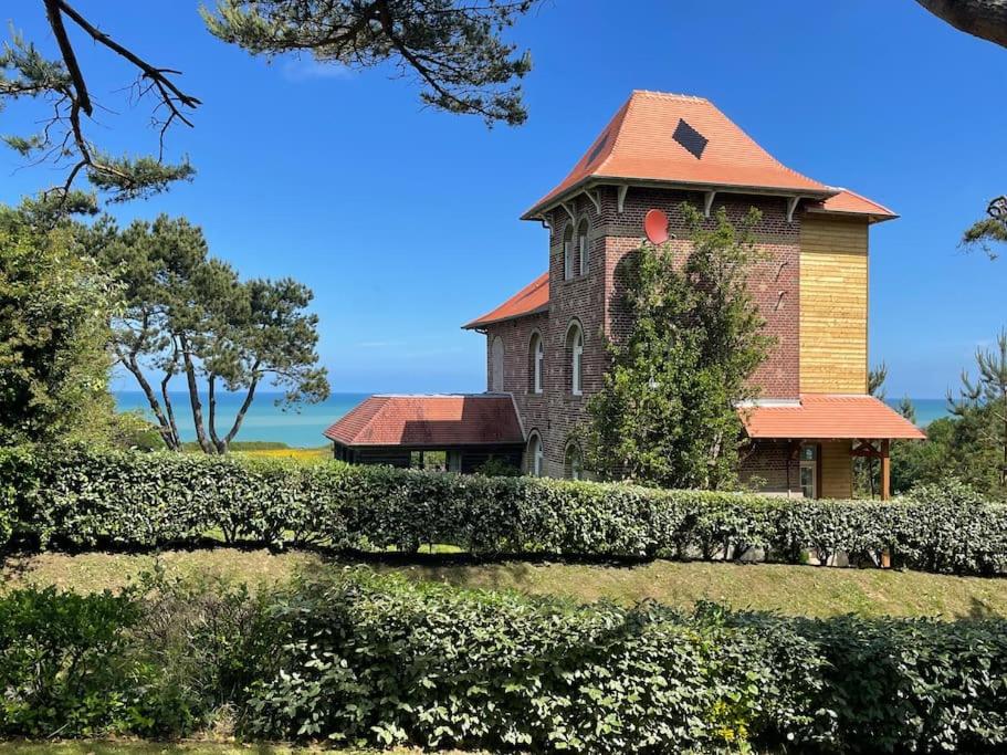 ein großes Backsteingebäude mit rotem Dach in der Unterkunft Le colombier, villa vue mer accès plage 300M in Varengeville-sur-Mer