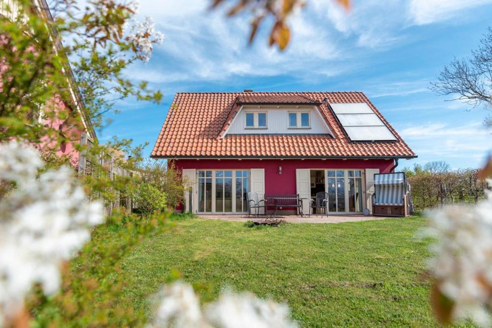 a red house with a red roof on a yard at Ferienhaus Karnin A in Karnin (Usedom)