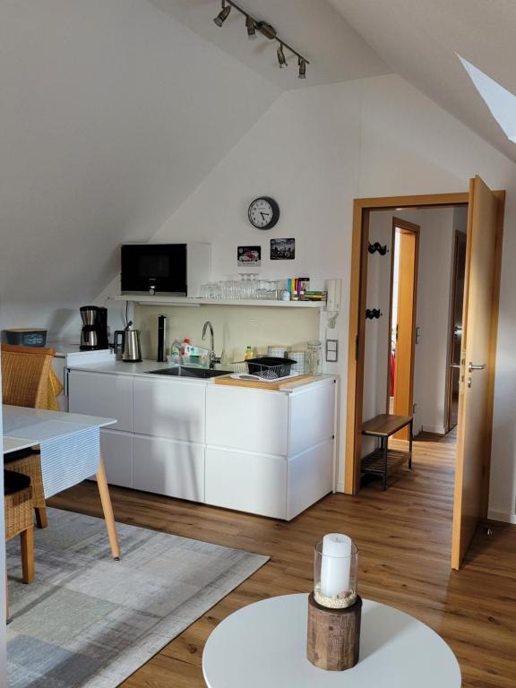 - une cuisine avec des placards blancs et une table dans une pièce dans l'établissement Apartment Sehring, à Oelde
