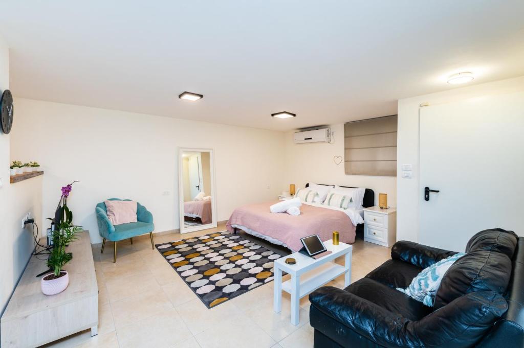 a living room with a bed and a couch at Cosy & Calm Central Getaway Modern Guest Suite by Midrachov 1 Queen Bed in Zikhron Ya‘aqov
