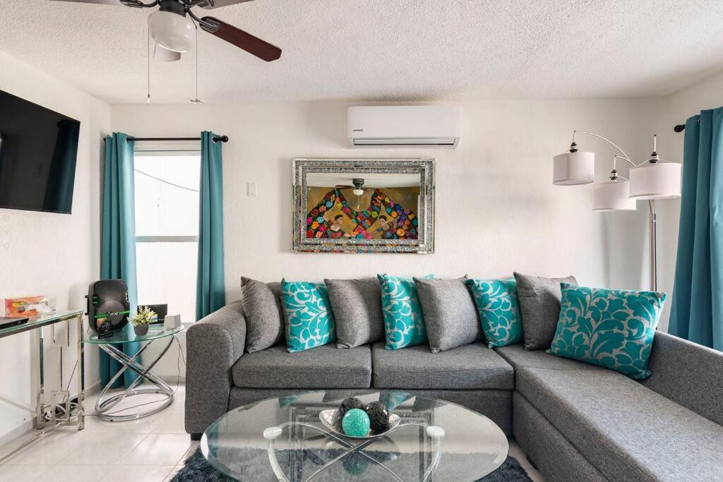uma sala de estar com um sofá e uma mesa de vidro em Casa MiAmore - Family Getaway em Cancún
