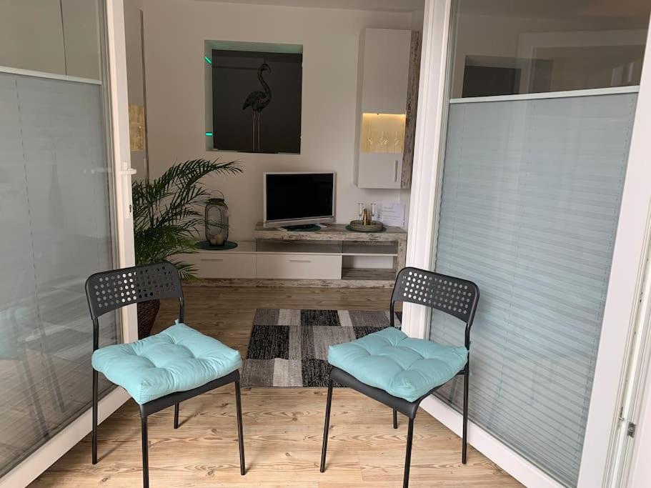 two chairs sitting on a balcony with a television at Gemütliche Wohnung mit guter Anbindung in Thaur