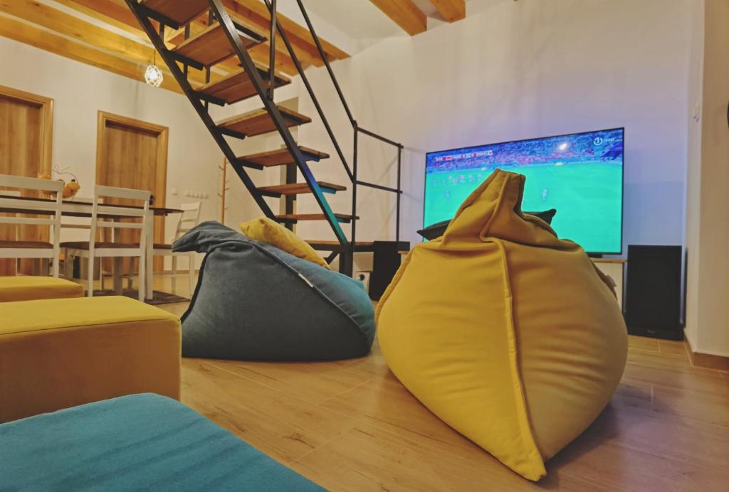 een woonkamer met kussens op de vloer en een televisie bij Holiday home D&D in Bosanska Krupa