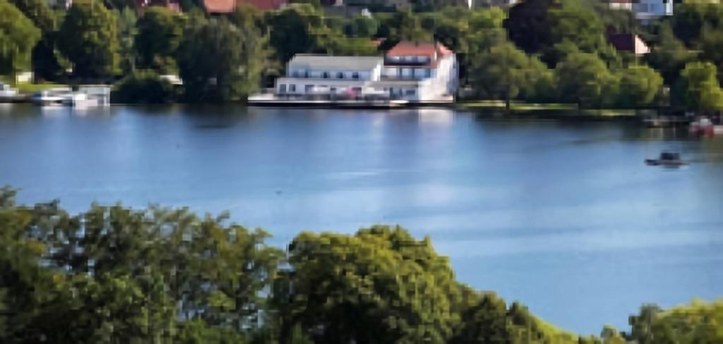 ein großes Gebäude am Ufer eines Sees in der Unterkunft Seehotel Krakow am See in Krakow am See