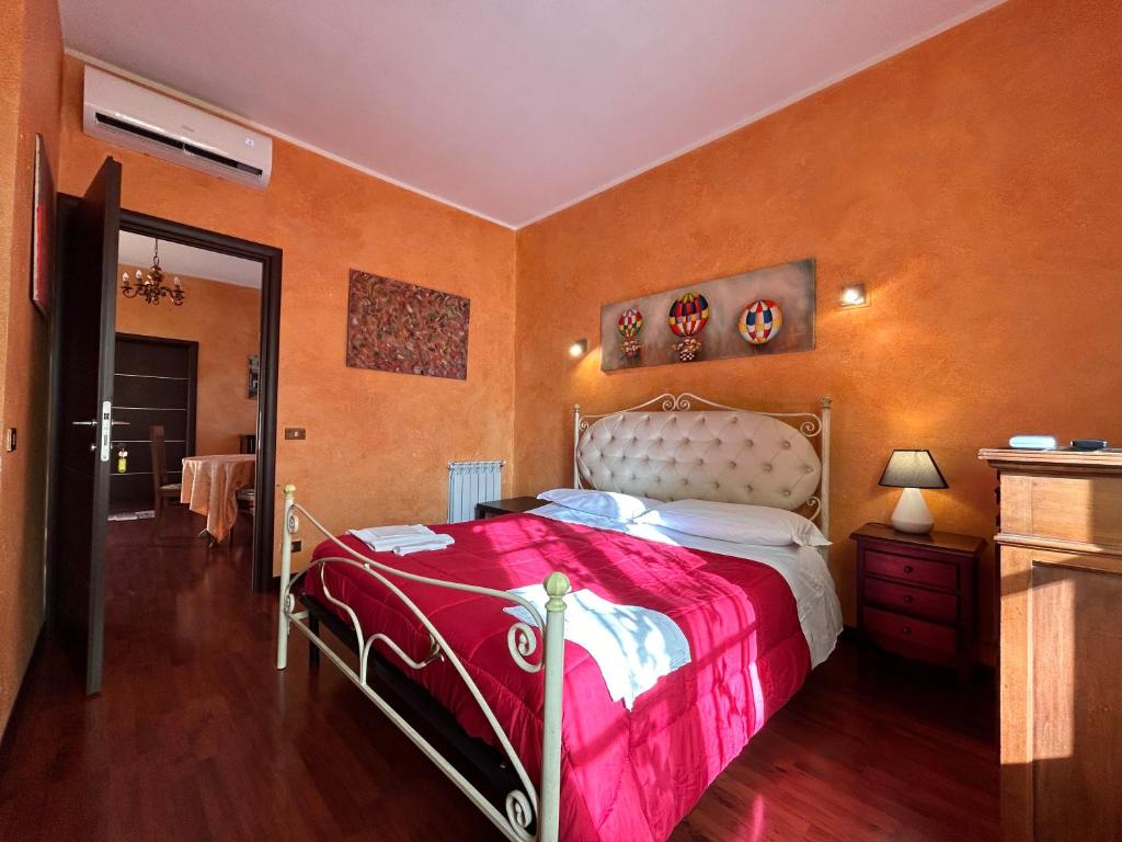 een slaapkamer met een groot bed en een roze deken bij L'antico Granaio in Paliano