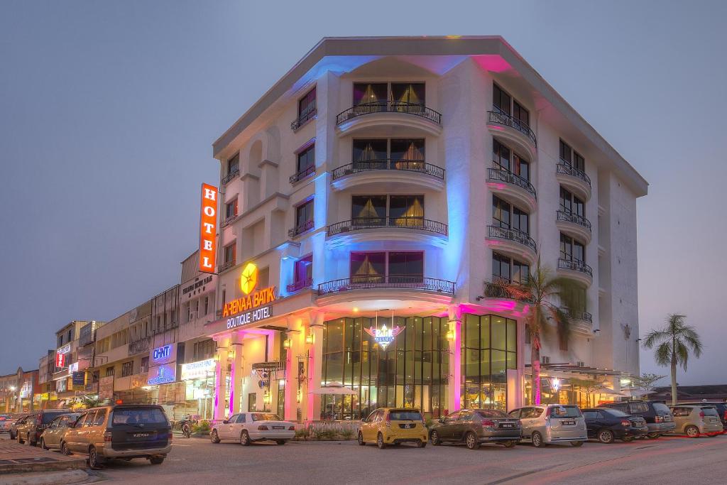 un gran edificio con coches estacionados frente a él en Arenaa Batik Boutique, en Kuantan