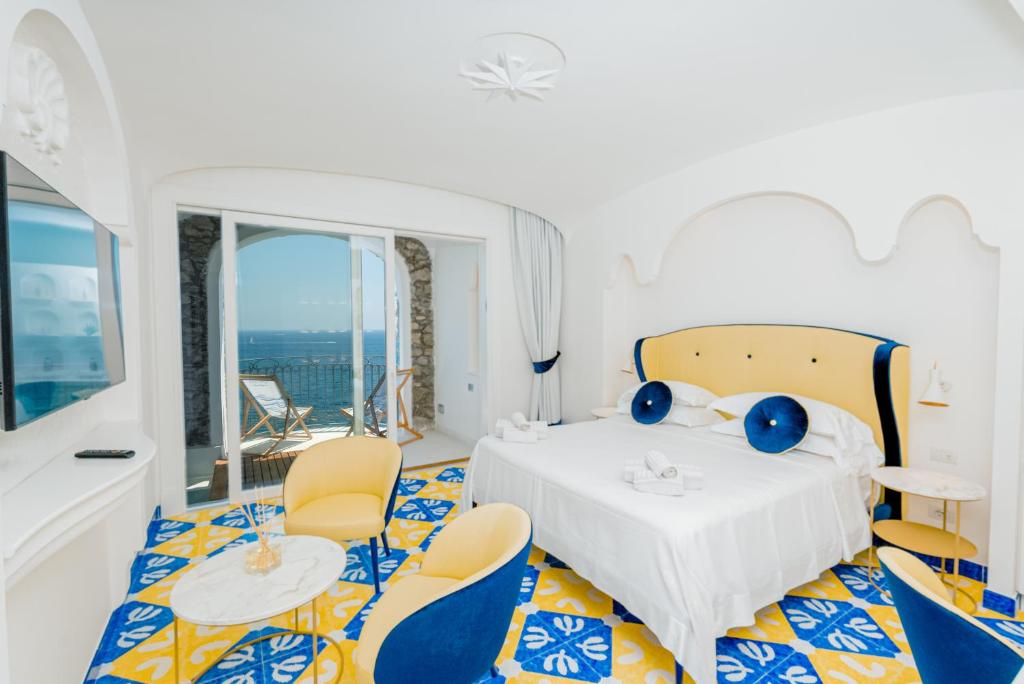 a room with a bed with chairs and a table at Hotel Cetus in Cetara