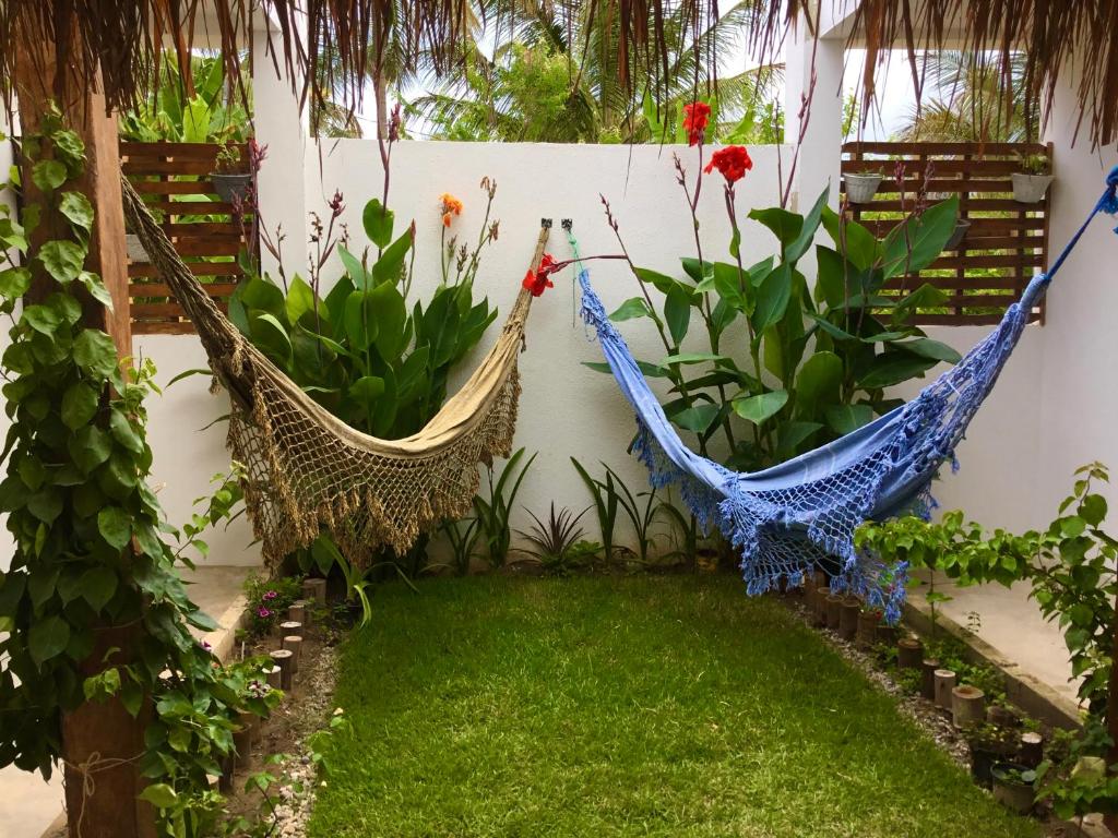 duas redes de descanso num jardim com plantas em Recanto de Maragogi em Maragogi