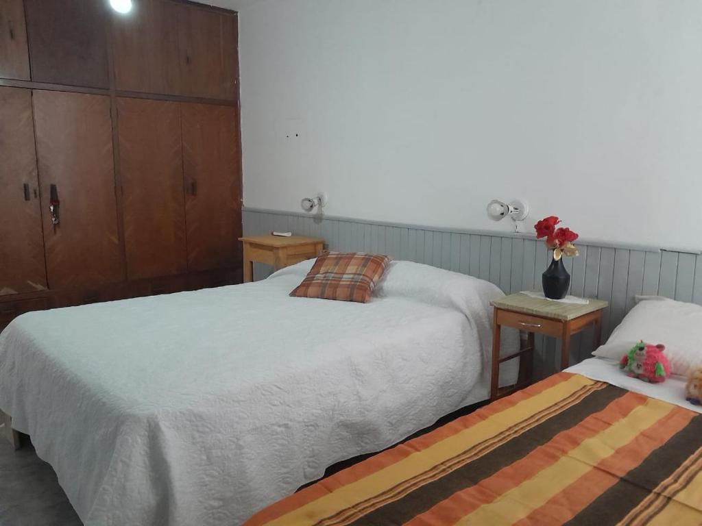 een slaapkamer met 2 bedden en een vaas met bloemen bij DEPARTAMENTO Alicia 1 in Santiago del Estero