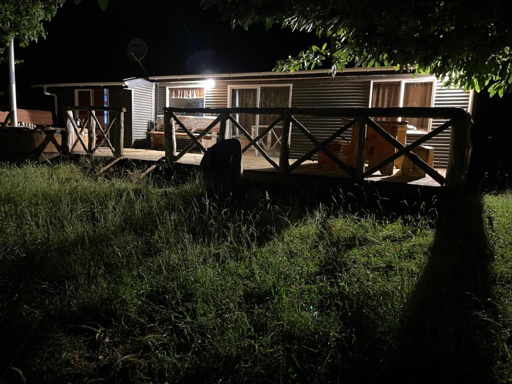 een hut 's nachts met een houten hek ervoor bij Cabañas Borde Lindo in San José de la Mariquina