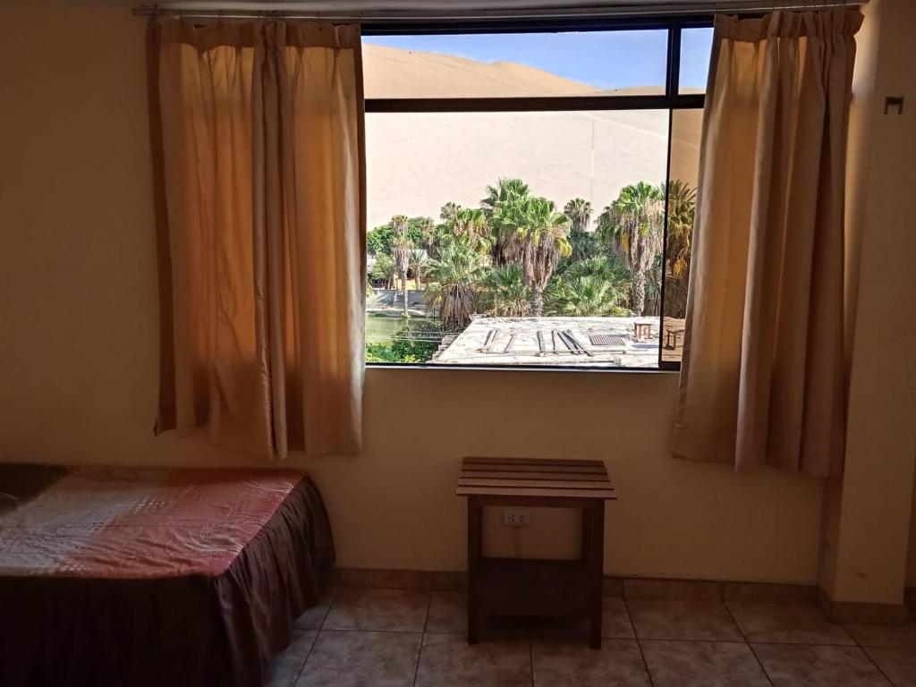 Postel nebo postele na pokoji v ubytování Hostal Huacachina Sunset