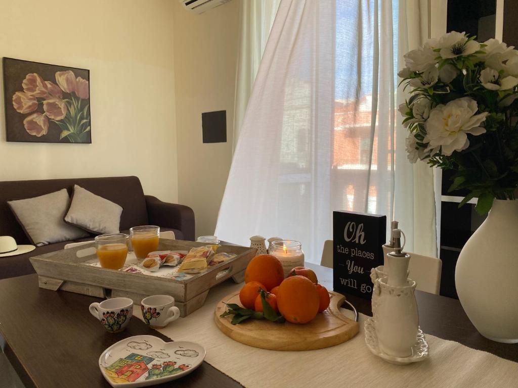 un tavolo con un vassoio di cibo e arance sopra di Palazzo Mongiò a Gallipoli