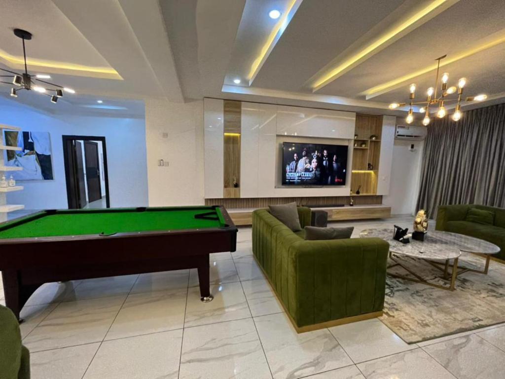 a living room with a pool table and a tv at Lovely 3-Bed with a Pool next to Four Point in Lagos