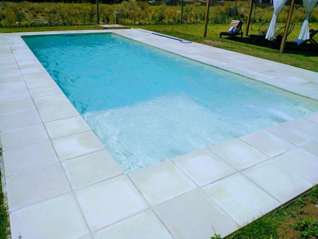 a swimming pool with blue water and white tiles at La Querencia in San Rafael
