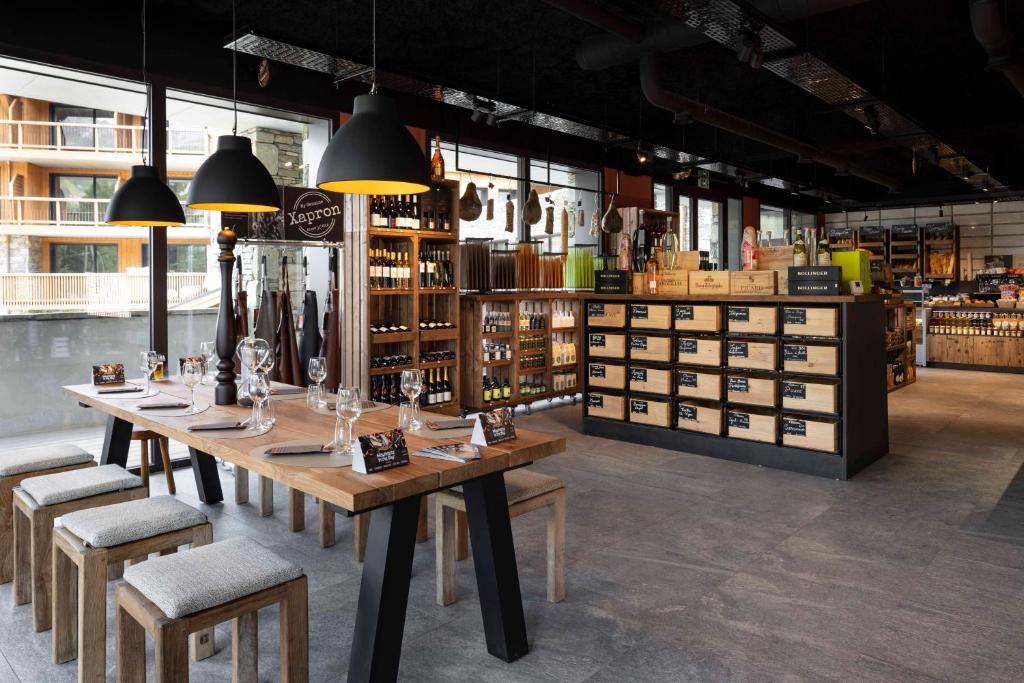 a wine store with a long table and chairs at HIGALIK HOTEL in Les Menuires