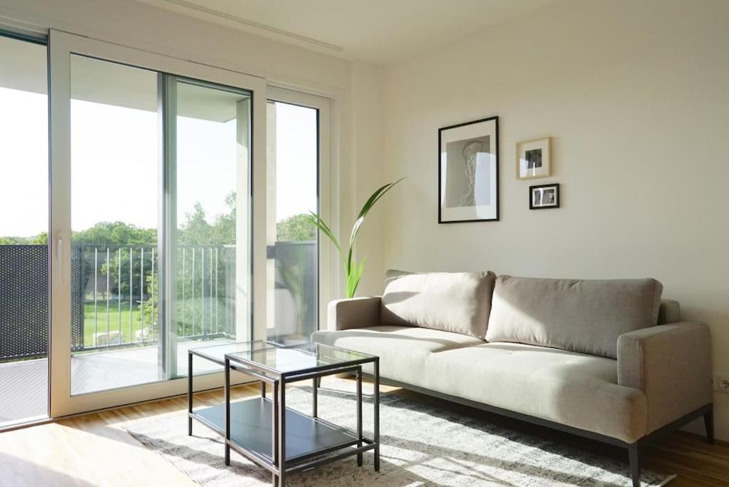 uma sala de estar com um sofá e uma mesa de vidro em Apartment with terrace near Metro Station and Spa em Viena