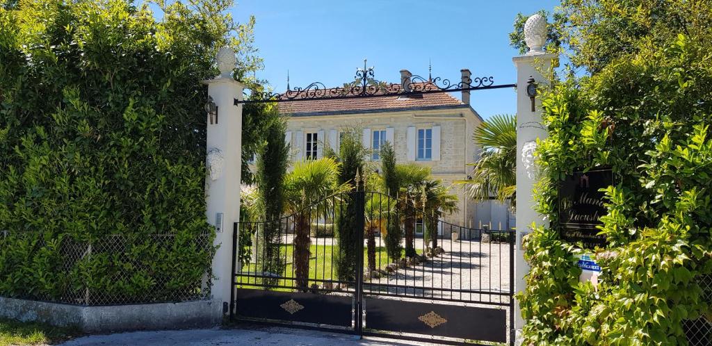 a gate to a mansion with palm trees at Le Manoir Lacustre in Queyrac