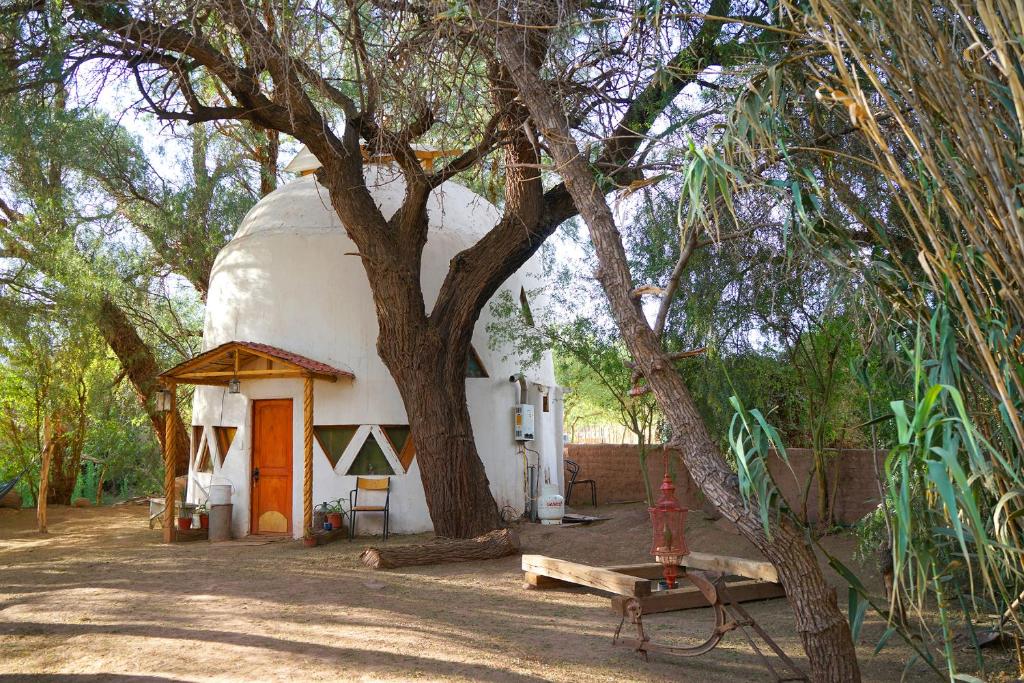 ein kleines Haus mit einem Baum davor in der Unterkunft Hermoso Domo ECOconstruido in San Pedro de Atacama