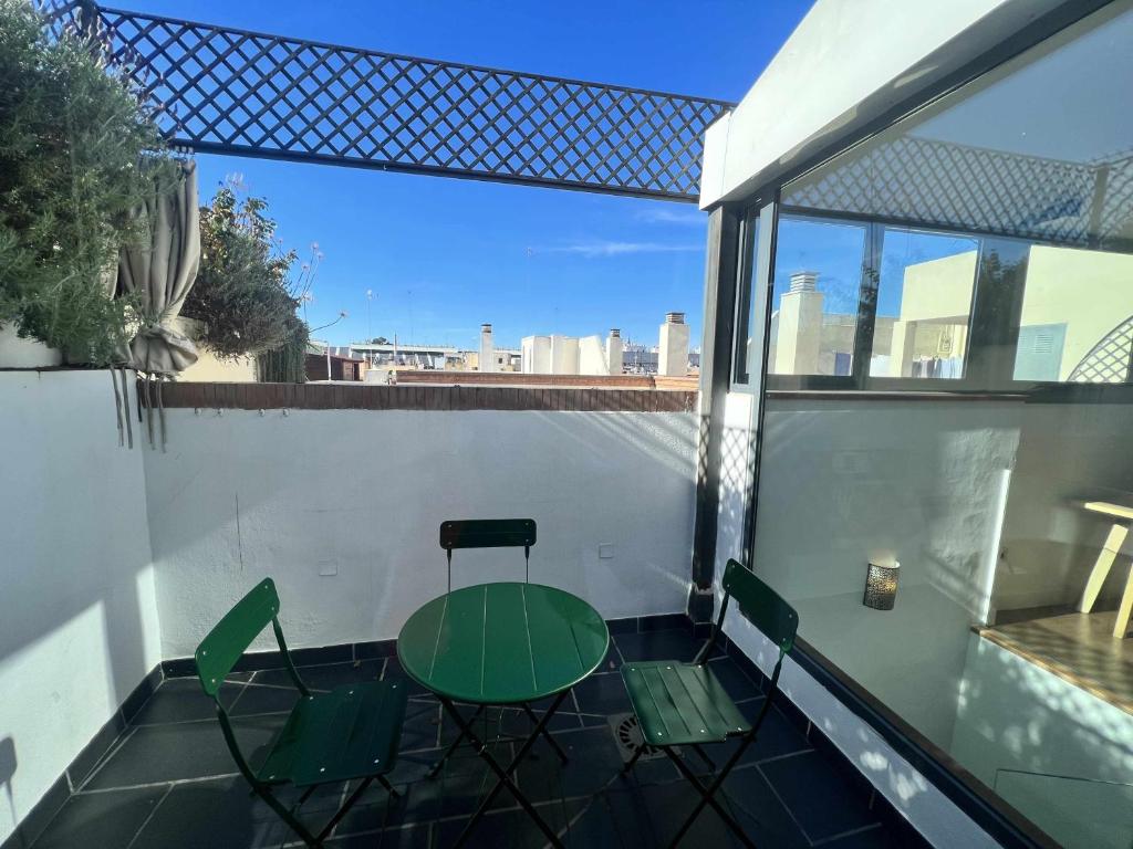 a patio with a table and chairs on a balcony at Ático San Bernardo Terraza y Parking Incluido in Seville