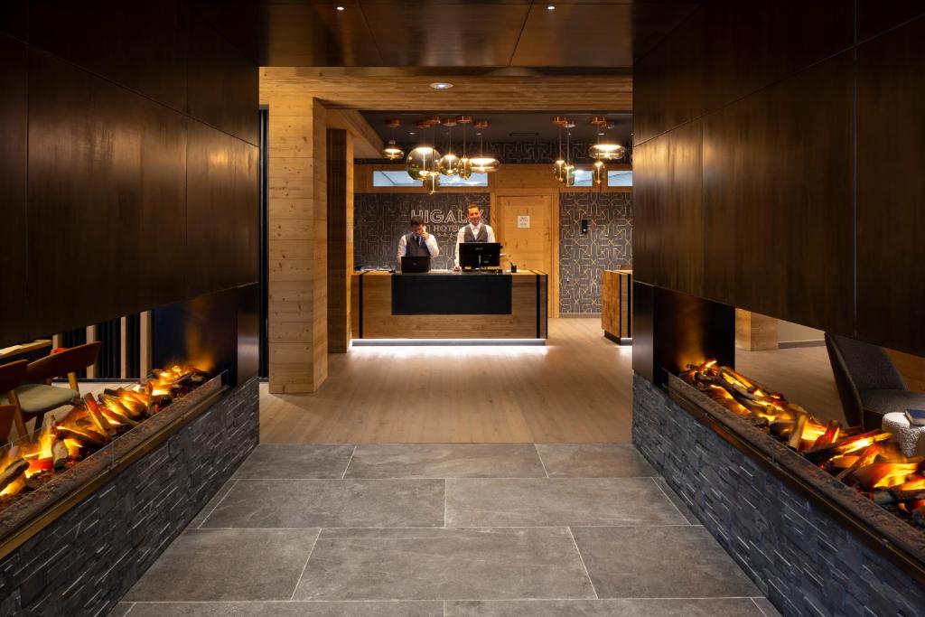 a lobby with two men standing at a counter at HIGALIK HOTEL in Les Menuires