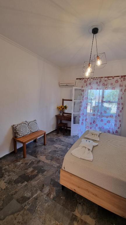 a bedroom with a bed and a bench and a window at Anna Garden Sidari in Sidari