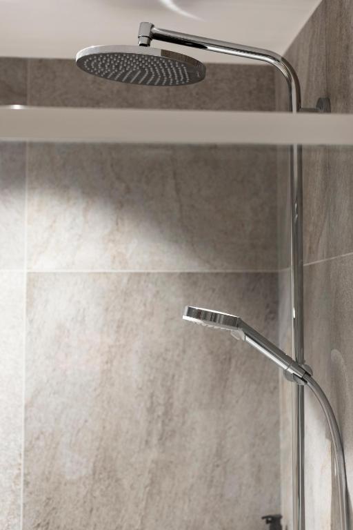 a shower with a shower head in a bathroom at HIGALIK HOTEL in Les Menuires