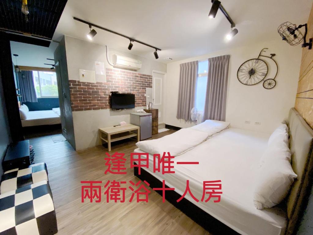 een slaapkamer met 2 bedden en een klok aan de muur bij Fengjia dream house in Taichung
