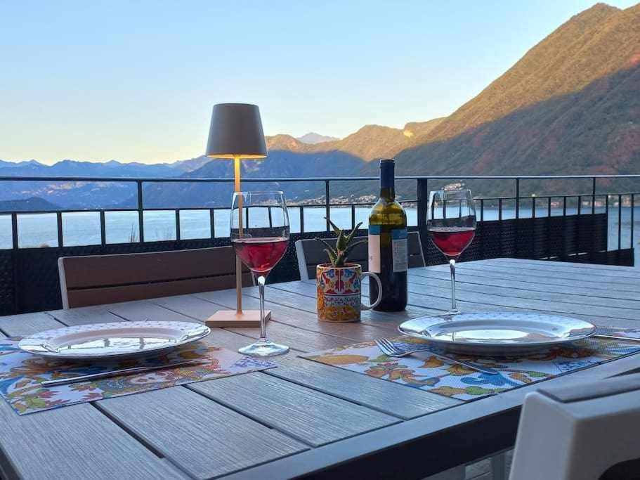 una mesa con dos copas de vino y una botella en Una terrazza sul lago, en Argegno