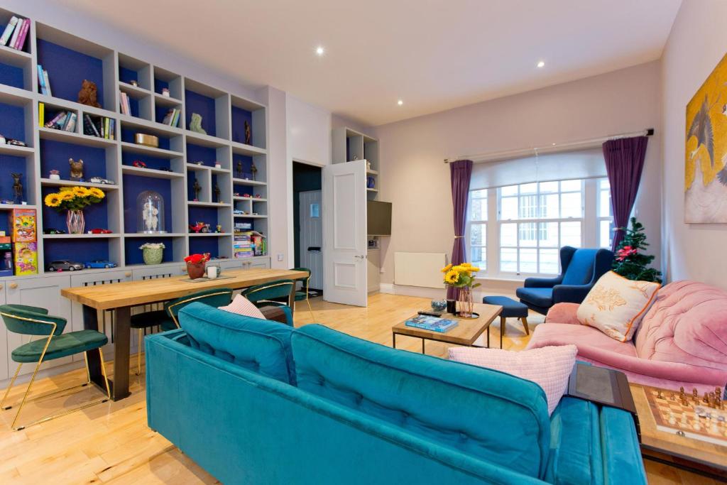 - un salon avec un canapé bleu et une table dans l'établissement 3 Bedroom Modern Mews House, à Londres