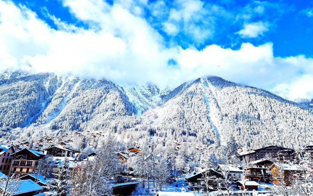 une montagne recouverte de neige devant une ville dans l'établissement La Riviere - Aiguille du Midi, à Chamonix-Mont-Blanc
